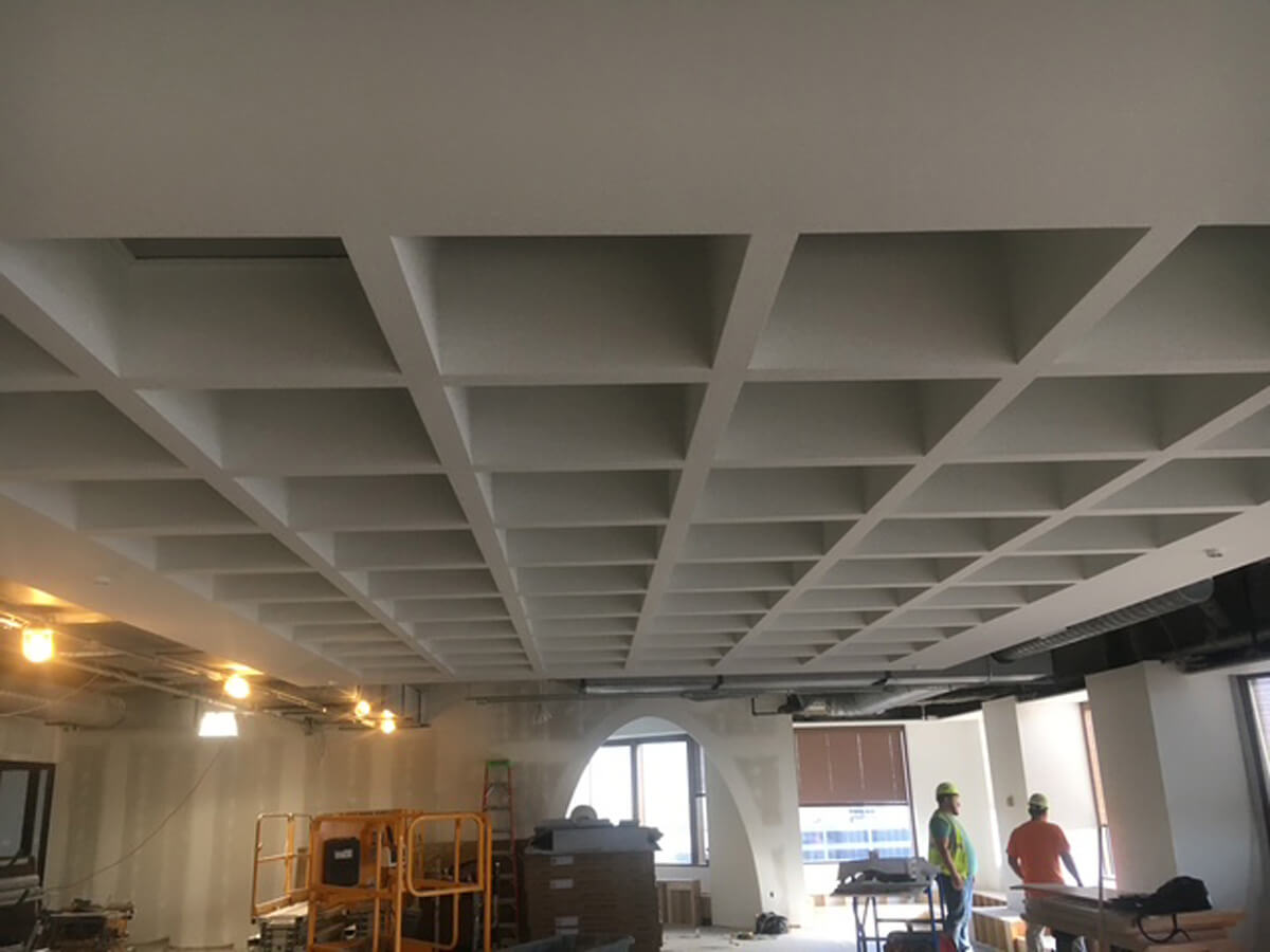 Finished custom coffered grid drywall ceiling in a commercial office space under construction.